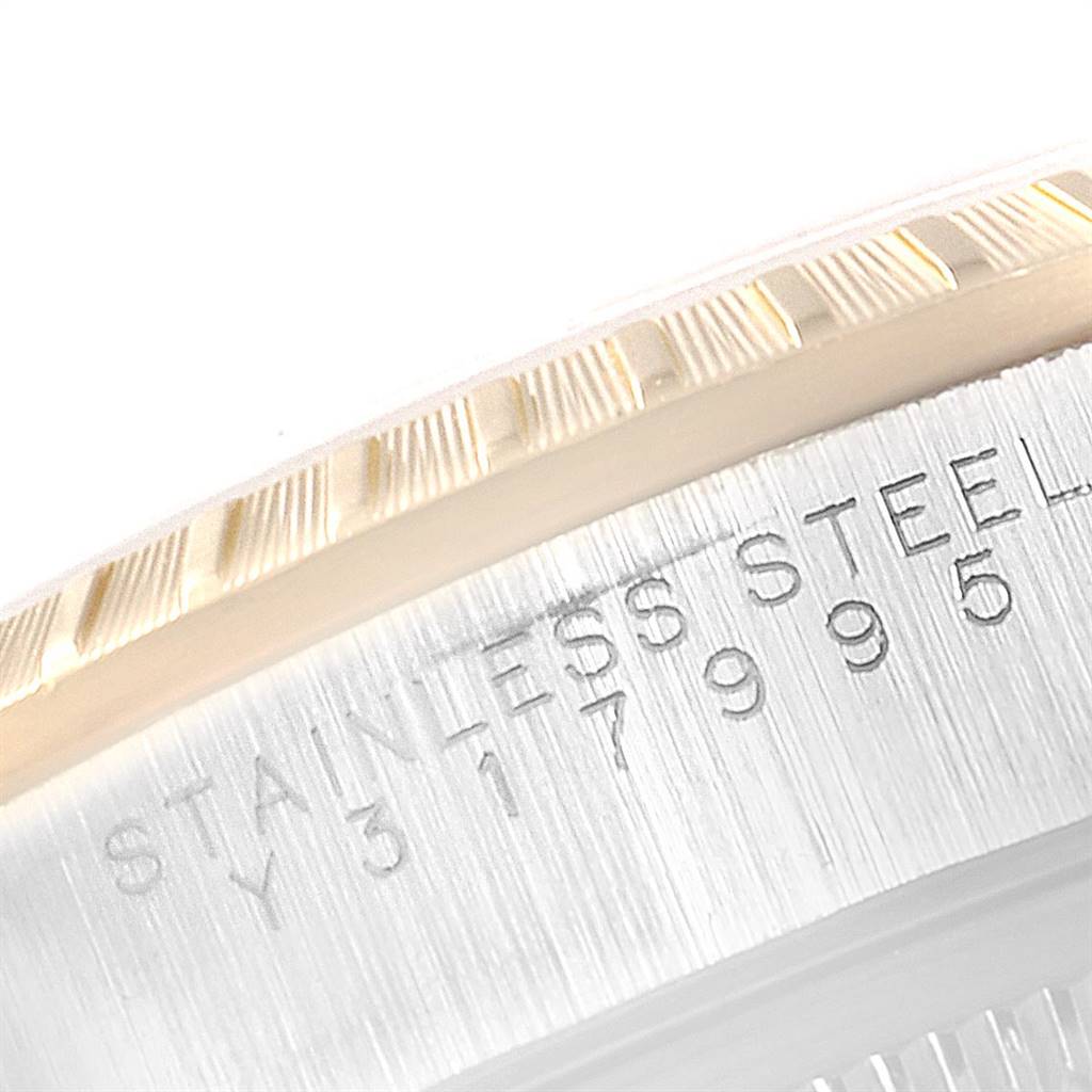 The image shows a close-up of the Rolex Date 15223 Men's Steel and Gold (two tone) White Dial 15223 Men's Steel and Gold (two tone) White Dial model's fluted bezel and part of its stainless steel case with engraving.