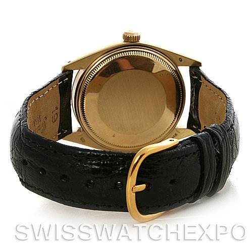 The image shows the back view of a Rolex Date 1503 Men
s Yellow Gold Champagne Dial 1503 Men
s Yellow Gold Champagne Dial watch with a gold case and black leather strap.