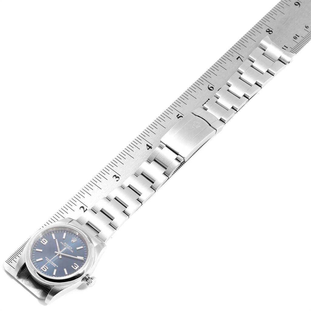 This image shows a Rolex Date 116000 Men's Stainless Steel Blue Dial 116000 Men's Stainless Steel Blue Dial model watch laid flat, including the face, band, and clasp alongside a ruler for measurement.
