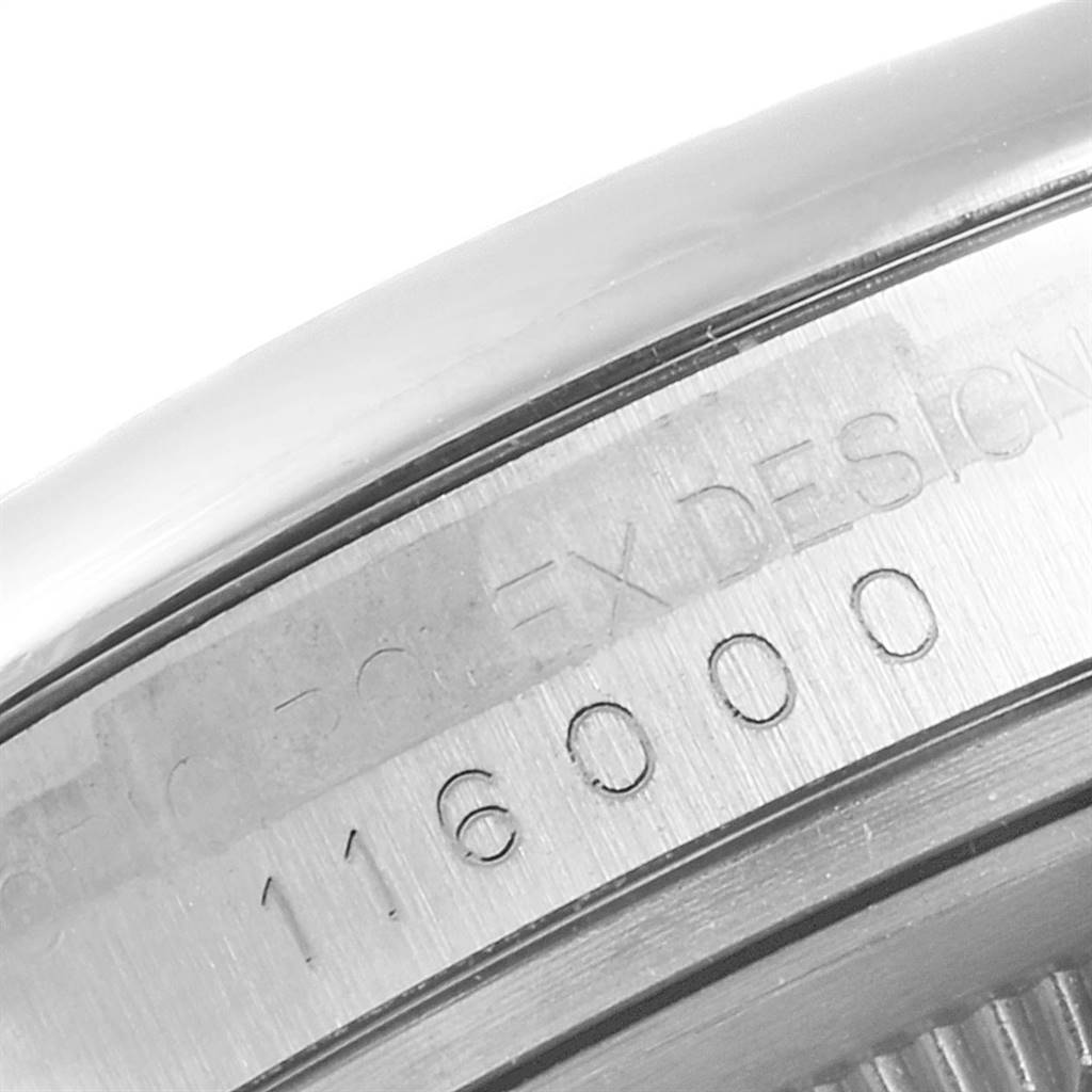 The image shows a close-up of the Rolex Date 116000 Men's Stainless Steel Blue Dial 116000 Men's Stainless Steel Blue Dial model's case side with engraved writing and its reference number, 116000.