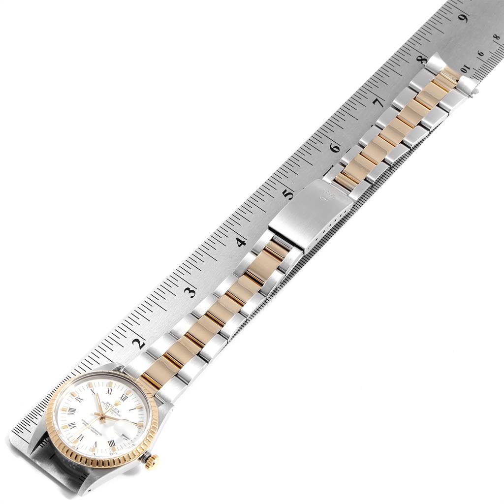 The image shows a Rolex Date 15053 Men's Steel and Gold (two tone) White Dial 15053 Men's Steel and Gold (two tone) White Dial model watch with a metal band laid flat against a ruler, highlighting measurements.