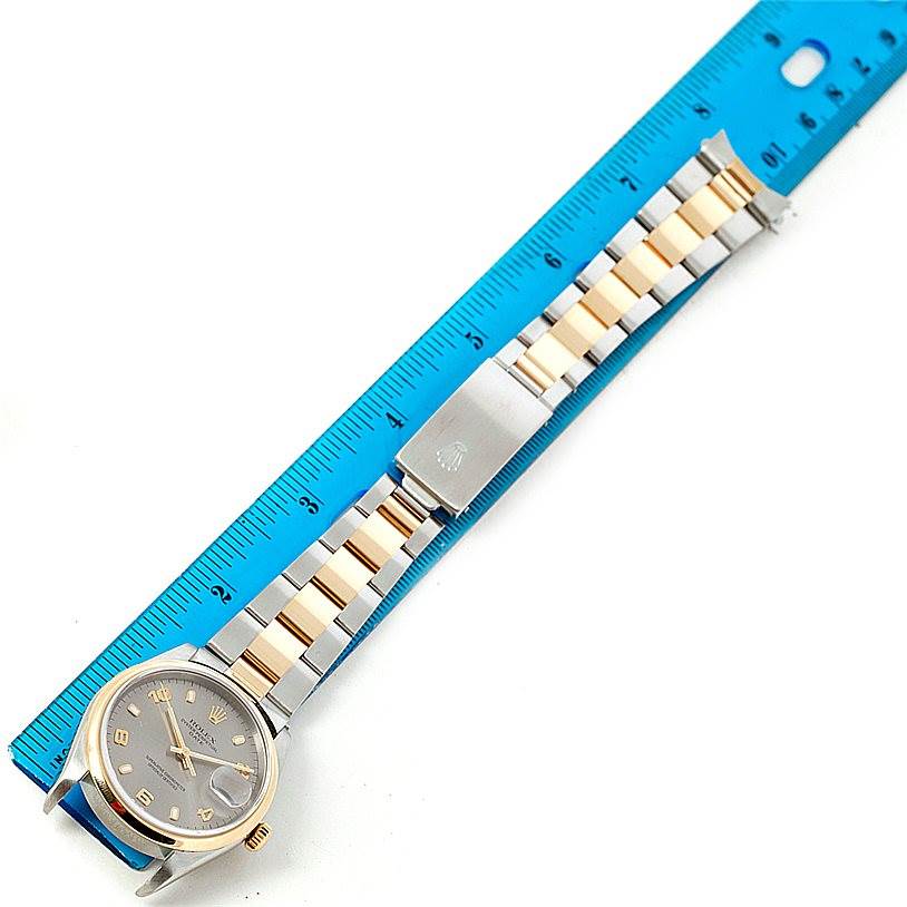 This image shows a Rolex Date 15203 Men's Steel and Gold (two tone) Grey Dial 15203 Men's Steel and Gold (two tone) Grey Dial model watch laid flat next to a ruler, displaying the dial, band, and clasp.