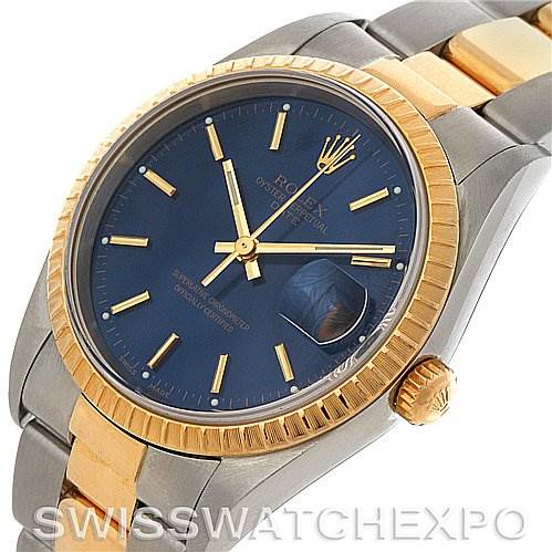 The image shows a close-up, angled view of a Rolex Date 15223 Men's Steel and Gold (two tone) Blue Dial 15223 Men's Steel and Gold (two tone) Blue Dial model watch, highlighting the blue dial, gold fluted bezel, and part of the bracelet.
