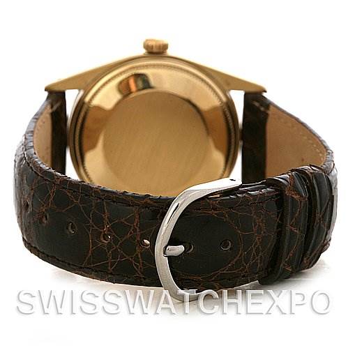 The image shows the back view of a Rolex Date 15037 Men's Yellow Gold Champagne Dial 15037 Men's Yellow Gold Champagne Dial model watch with its gold case, brown leather strap, and silver buckle.