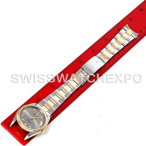 The Rolex Date 15223 Men's Steel and Gold (two tone) Grey Dial 15223 Men's Steel and Gold (two tone) Grey Dial watch is shown from a top-down angle, displaying the full face and band alongside a red ruler for scale.