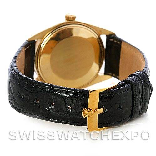 The image shows the back case of a Rolex Date 1503 Men's Yellow Gold Silver Dial 1503 Men's Yellow Gold Silver Dial model watch with a gold case and a black leather strap from a rear angle.
