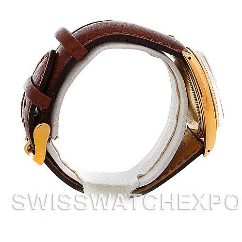 The image shows a side view of a Rolex Date 1503 Men's Yellow Gold Champagne Dial 1503 Men's Yellow Gold Champagne Dial model watch with a brown leather strap and gold accents on the case and clasp.