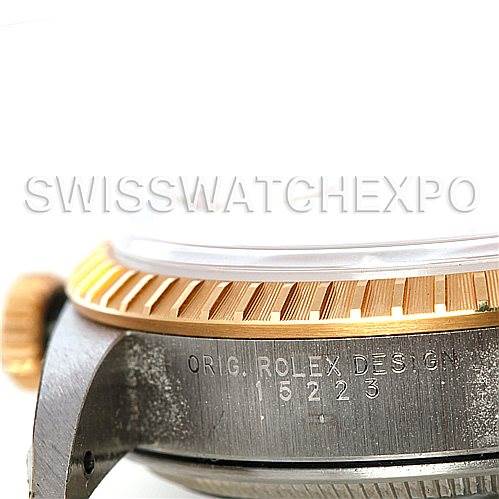 This image shows a side view of a Rolex Date 15223 Men's Steel and Gold (two tone) Silver Dial 15223 Men's Steel and Gold (two tone) Silver Dial model watch case, displaying the crown, bezel, and part of the watch face, with serial and design numbers visible.