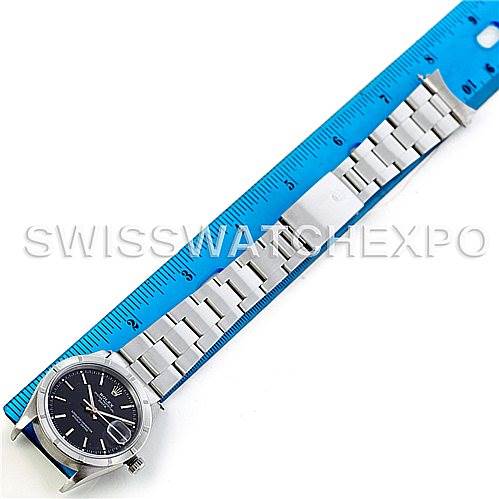 This image shows a Rolex Date 15210 Men's Stainless Steel Black Dial 15210 Men's Stainless Steel Black Dial model watch with its bracelet fully extended along a blue ruler for measurement.