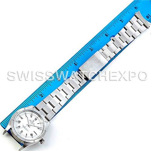 This image shows a top-down view of a Rolex Date 15210 Men's Stainless Steel White Dial 15210 Men's Stainless Steel White Dial model watch fully extended beside a blue ruler.
