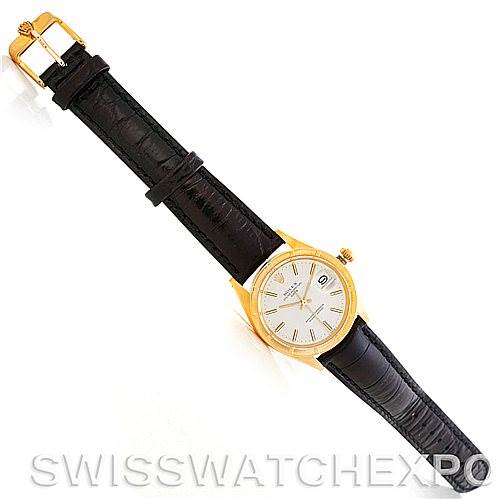 The image shows a top-down view of a Rolex Date 1501 Men
s Yellow Gold Silver Dial 1501 Men
s Yellow Gold Silver Dial model watch with a gold case and a black leather strap.