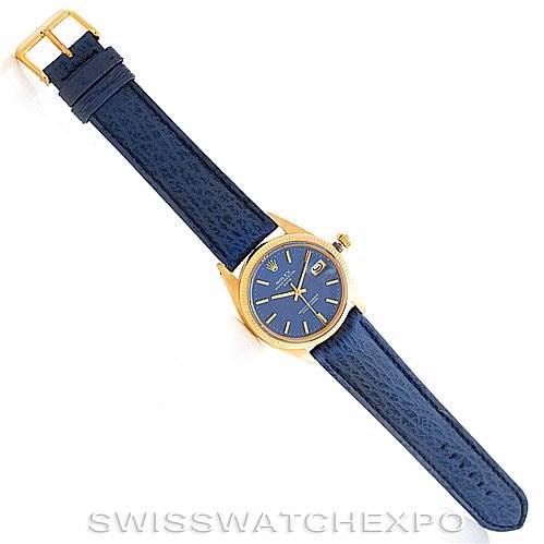 This image shows a top-down view of a Rolex Date 1500 Men's Yellow Gold Blue Dial 1500 Men's Yellow Gold Blue Dial model watch with a blue leather strap and gold casing.
