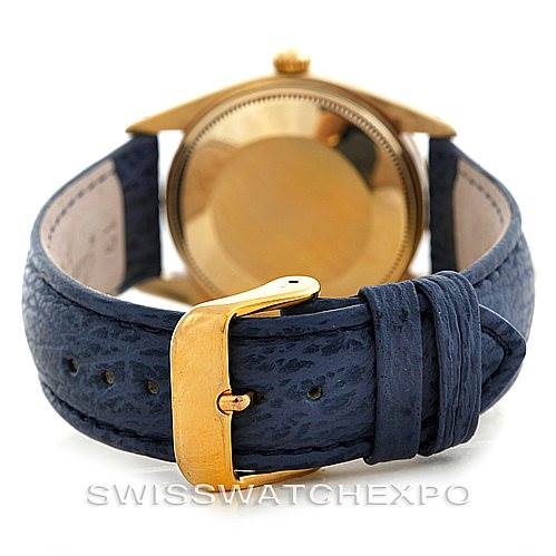 The image shows the back of a Rolex Date 1500 Men's Yellow Gold Blue Dial 1500 Men's Yellow Gold Blue Dial model watch, focusing on the case back and blue leather strap with a gold buckle.