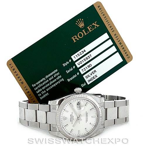The image shows a Rolex Date 115234 Men's Stainless Steel Silver Dial 115234 Men's Stainless Steel Silver Dial watch with its face, bracelet, and a warranty card placed behind it.