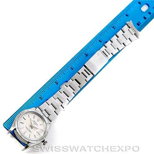 This image shows a Rolex Date 15210 Men's Stainless Steel Silver Dial 15210 Men's Stainless Steel Silver Dial watch laid flat against a ruler, showcasing the watch face and stainless steel bracelet.