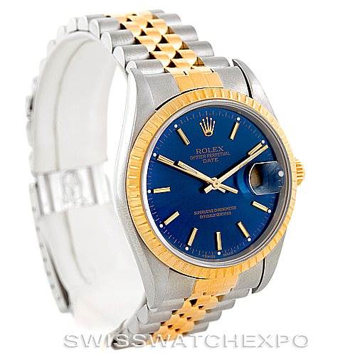 The image shows a Rolex Date 15223 Men's Steel and Gold (two tone) Blue Dial 15223 Men's Steel and Gold (two tone) Blue Dial watch, angled to reveal its blue dial, two-tone bracelet, and fluted bezel.
