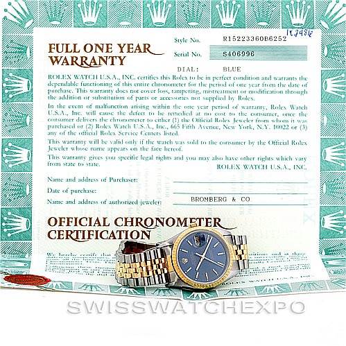 The image shows a Rolex Date 15223 Men's Steel and Gold (two tone) Blue Dial 15223 Men's Steel and Gold (two tone) Blue Dial model watch lying flat, along with its warranty and chronometer certification papers.