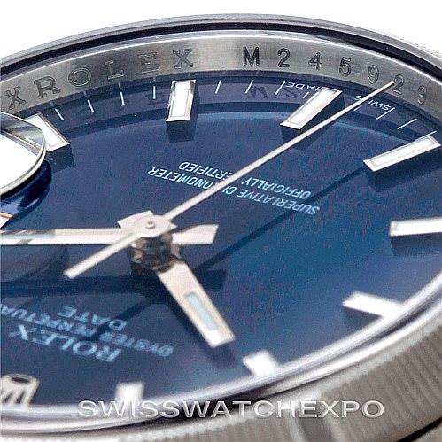This image shows a close-up angle of the Rolex Date 115210 Men's Stainless Steel Blue Dial 115210 Men's Stainless Steel Blue Dial model's watch face, highlighting the dial, hands, markers, and serial number.