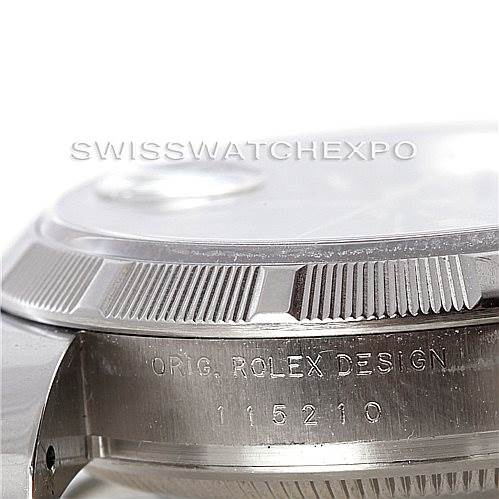 This image shows a close-up of the Rolex Date 115210 Men's Stainless Steel Blue Dial 115210 Men's Stainless Steel Blue Dial model's case side and bezel with the serial number and "Orig. Rolex Design" engraving.