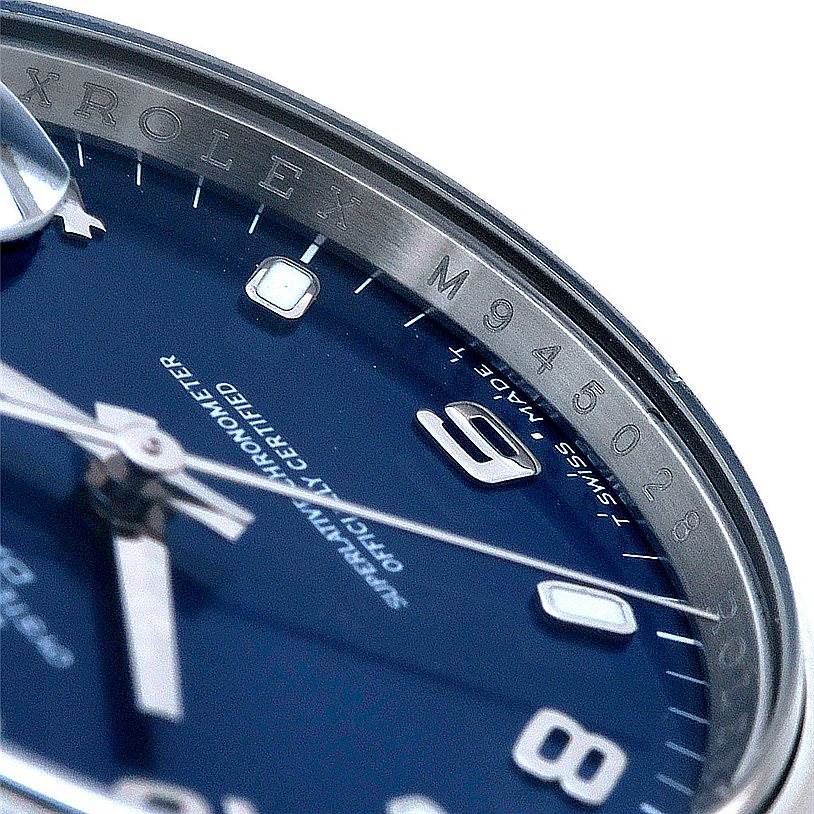 The image shows a close-up of the dial, bezel, and serial number of a Rolex Date 115200 Men's Stainless Steel Blue Dial 115200 Men's Stainless Steel Blue Dial model watch.