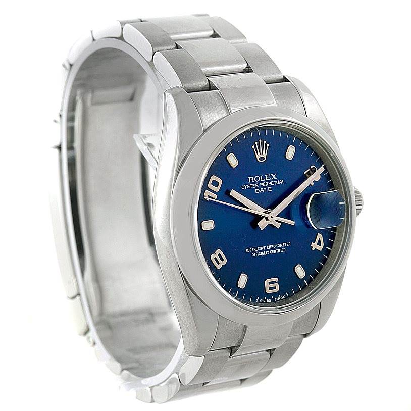 The image shows a Rolex Date 115200 Men's Stainless Steel Blue Dial 115200 Men's Stainless Steel Blue Dial model watch viewed from a slight angle, showcasing its blue dial and stainless steel bracelet.