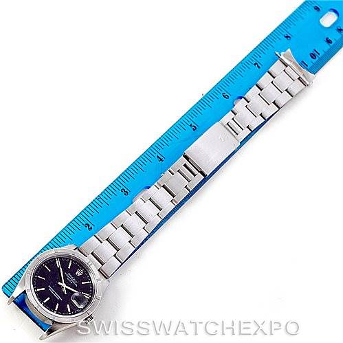 This image shows a Rolex Date 15210 Men's Stainless Steel Black Dial 15210 Men's Stainless Steel Black Dial model watch laid flat next to a blue ruler, displaying the watch face and bracelet from above.