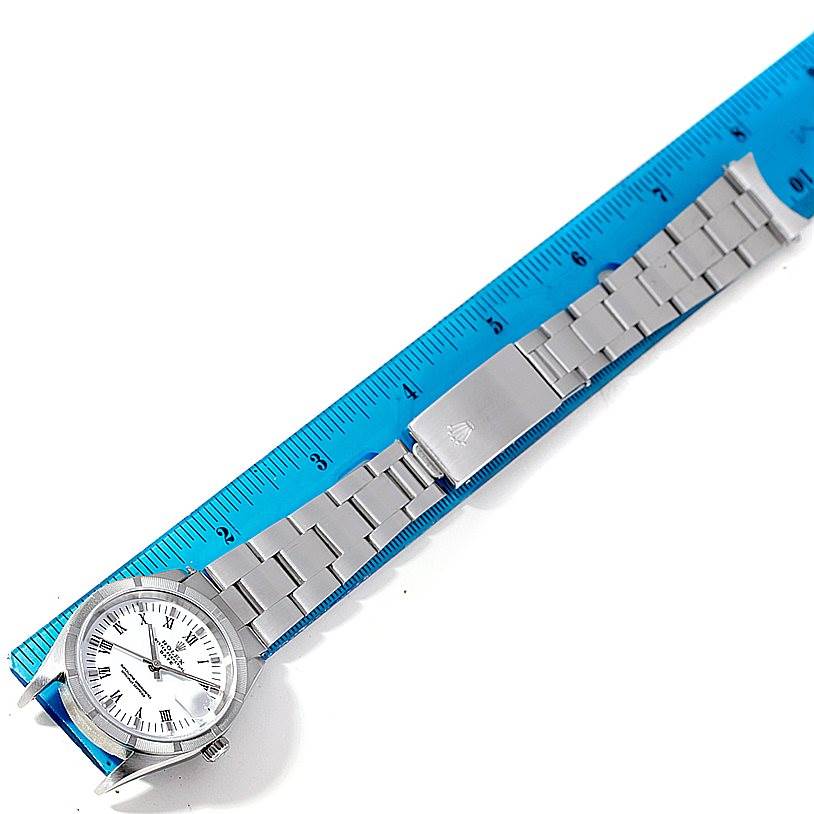 The Rolex Date 15210 Men's Stainless Steel White Dial 15210 Men's Stainless Steel White Dial model watch is shown flat with its face, band, and clasp next to a blue ruler.