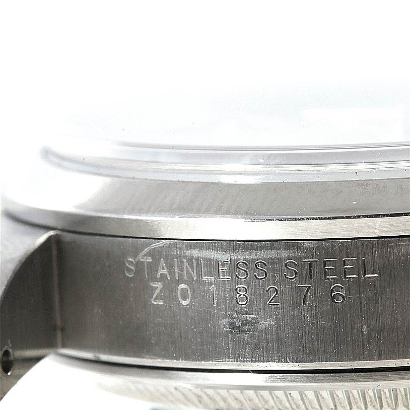 The image shows an angled close-up of the side of a Rolex Date 15200 Men's Stainless Steel Silver Dial 15200 Men's Stainless Steel Silver Dial model watch case, highlighting the "STAINLESS STEEL" engraving.