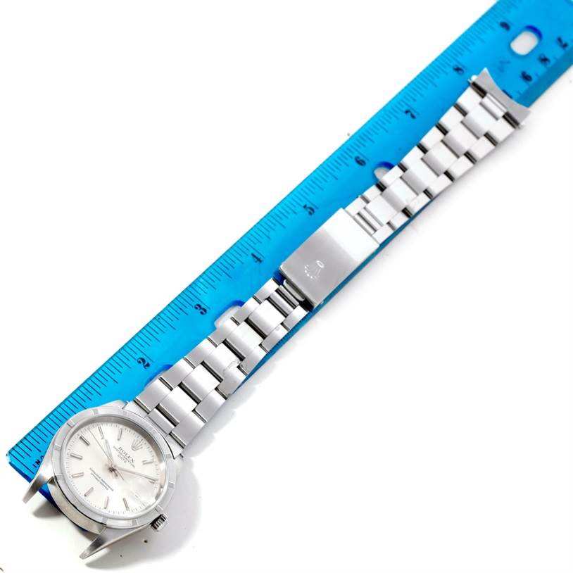 The image shows the Rolex Date 15210 Men's Stainless Steel Silver Dial 15210 Men's Stainless Steel Silver Dial watch lying flat against a ruler, displaying the dial, bracelet, and clasp.