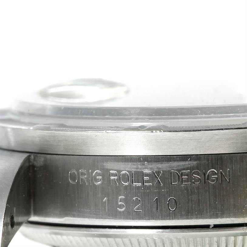 The image shows a close-up side view of a Rolex Date 15210 Men's Stainless Steel Black Dial 15210 Men's Stainless Steel Black Dial model, focusing on the engraved case with the design and model number.