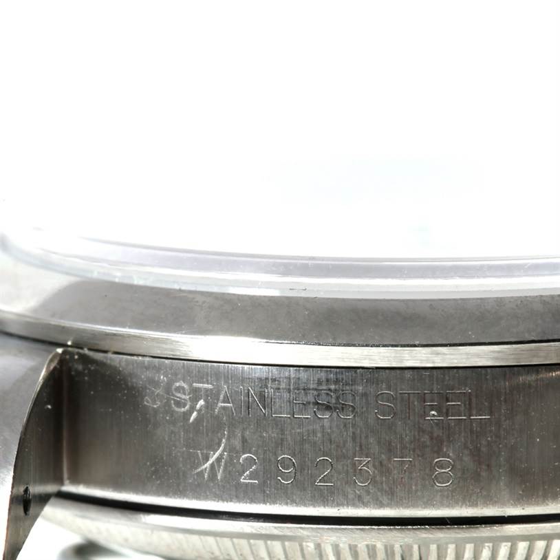 The image shows a close-up side view of the stainless steel case with serial numbers on a Date model Rolex watch.