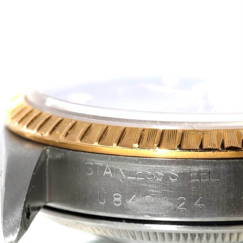 The image shows a close-up of the side view of a Rolex Date 15203 Men's Steel and Gold (two tone) Grey Dial 15203 Men's Steel and Gold (two tone) Grey Dial model, highlighting the fluted bezel and case engravings.