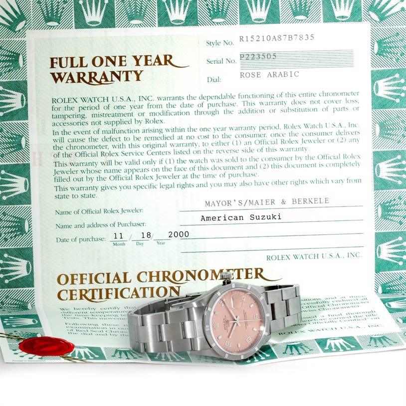 The image shows a Rolex Date 15210 Men's Stainless Steel Pink Dial 15210 Men's Stainless Steel Pink Dial model watch with a rose arabic dial alongside its full one-year warranty certificate.