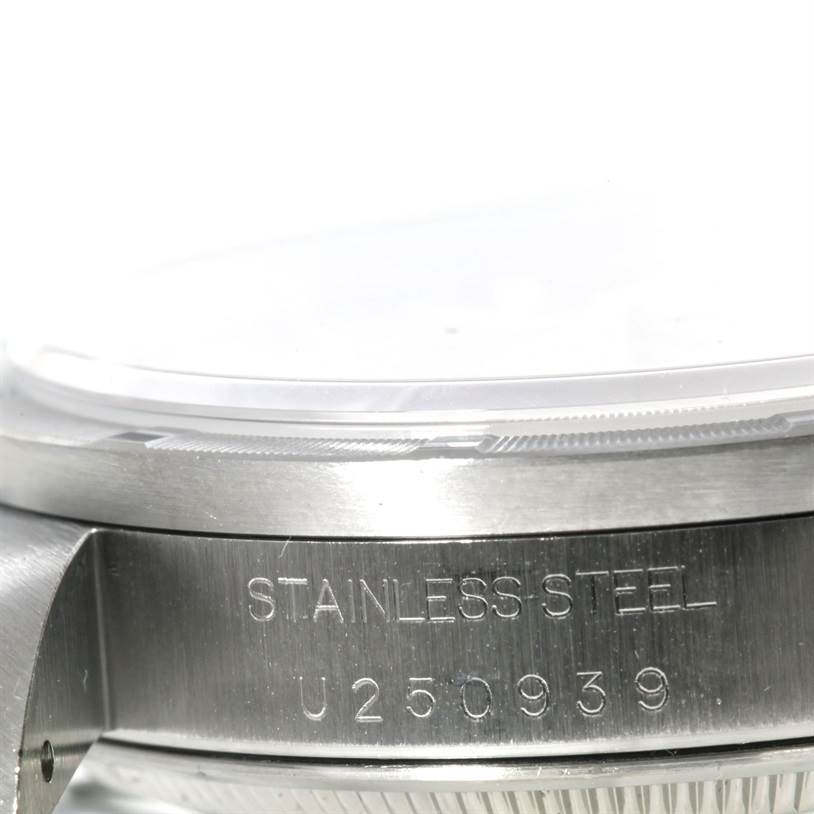 This image shows a close-up of the side case and bezel of the Rolex Date 15210 Men's Stainless Steel Pink Dial 15210 Men's Stainless Steel Pink Dial model watch, highlighting the "STAINLESS STEEL" engraving and serial number U250939.
