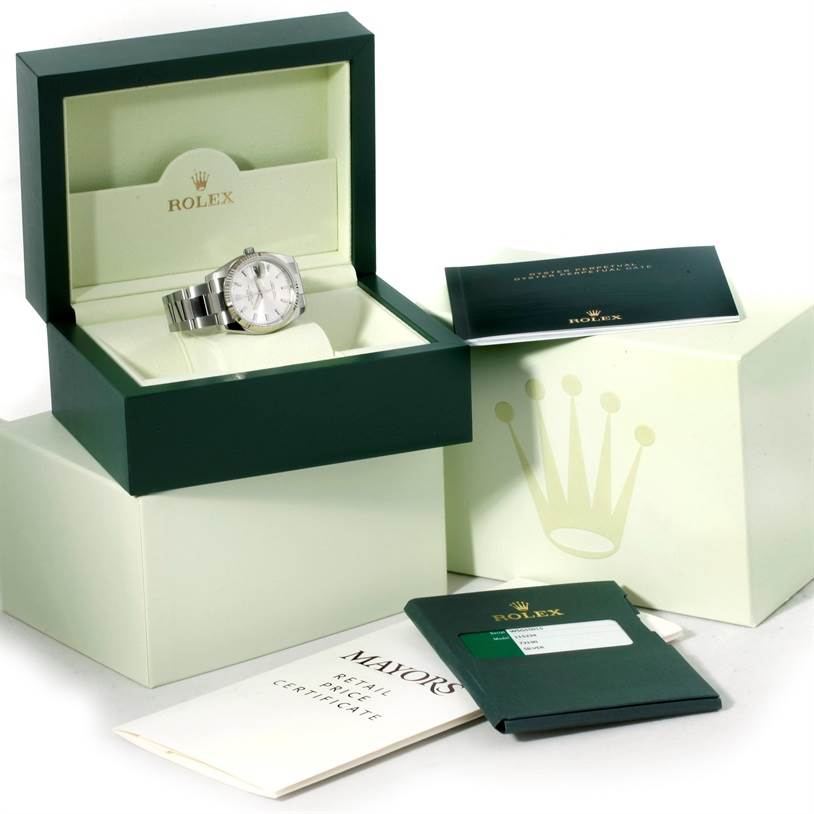 The image shows a Rolex Date 115234 Men's Stainless Steel Silver Dial 115234 Men's Stainless Steel Silver Dial model watch placed in its open box, accompanied by its outer box, warranty card, and user booklet.