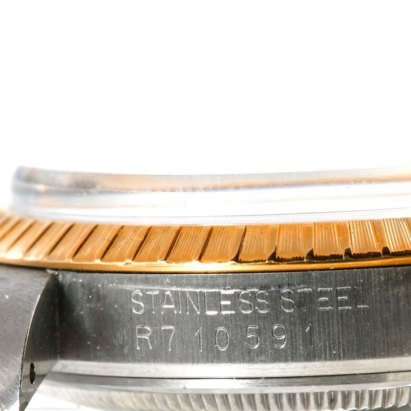This image shows a close-up of the side of a Rolex Date 15053 Men's Stainless Steel Champagne Dial 15053 Men's Stainless Steel Champagne Dial model, highlighting the bezel and the engraved case number.
