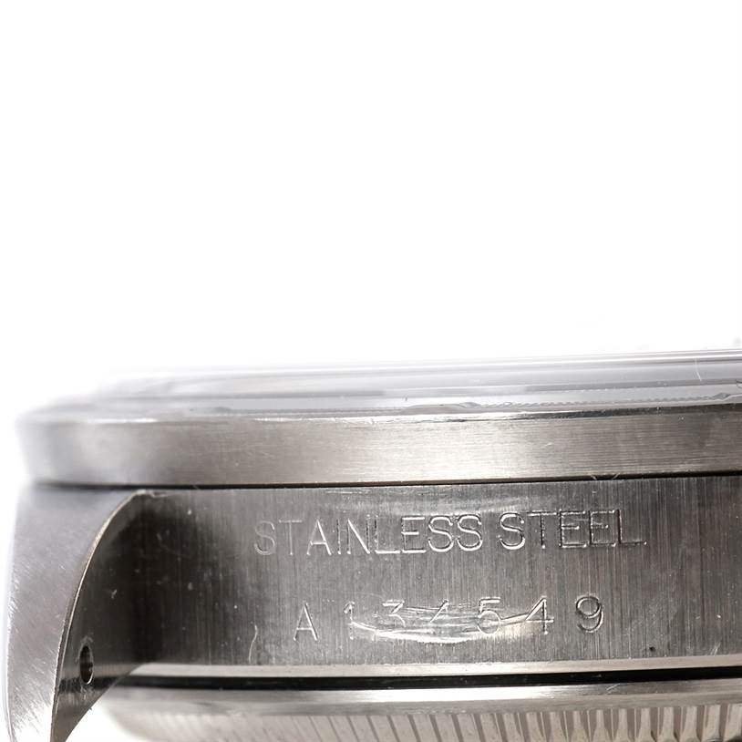 The image shows a close-up side view of a Rolex Date 15210 Men's Stainless Steel Black Dial 15210 Men's Stainless Steel Black Dial model’s stainless steel case with engraved serial numbers.