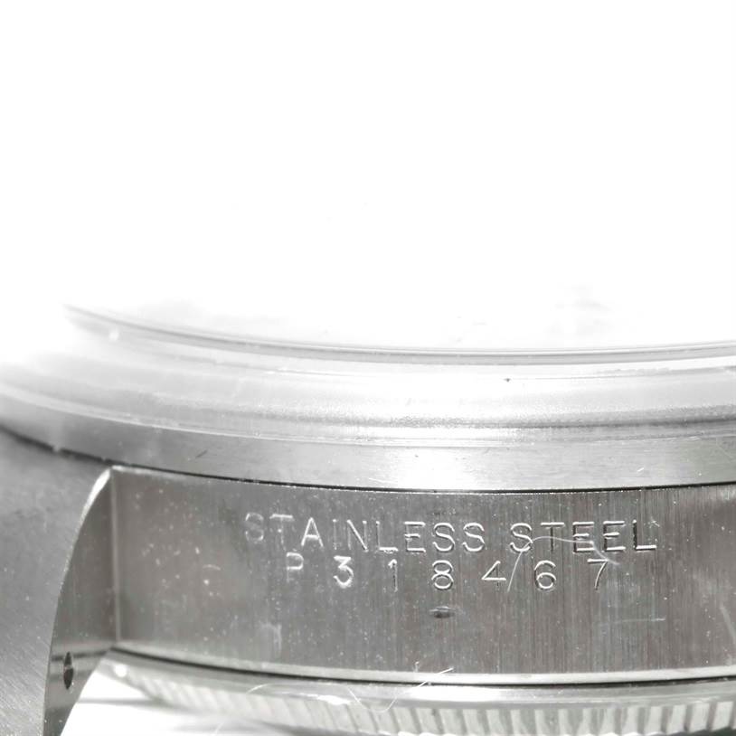 The image shows the side case of a Rolex Date 15210 Men's Stainless Steel White Dial 15210 Men's Stainless Steel White Dial model watch, highlighting the "STAINLESS STEEL" engraving and serial number.