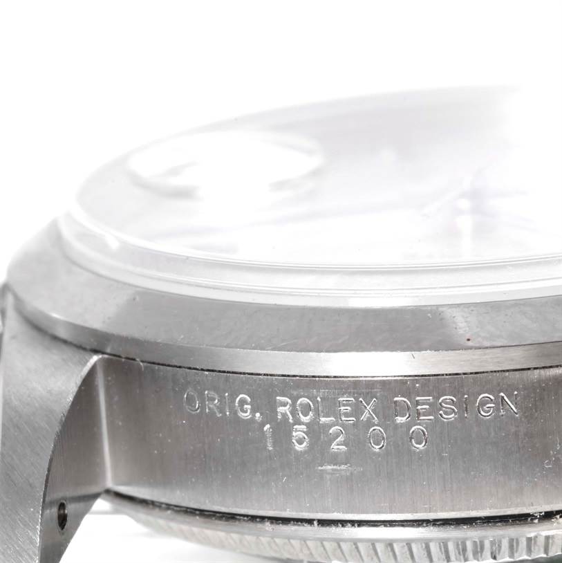 This close-up image of a Rolex Date 15200 Men's Stainless Steel Silver Dial 15200 Men's Stainless Steel Silver Dial model watch shows the side view of the case, focusing on the engravings and glass.