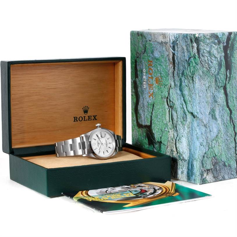 The Rolex Date 15200 Men's Stainless Steel Silver Dial 15200 Men's Stainless Steel Silver Dial model watch is displayed inside its open box, with the packaging and a booklet beside it.