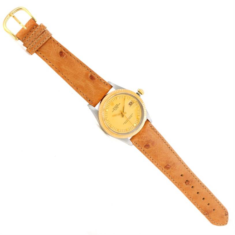 The Rolex Date 15053 Men's Stainless Steel Champagne Dial 15053 Men's Stainless Steel Champagne Dial model watch is shown from a top-down angle, displaying its face, dial, bezel, crown, and leather strap.