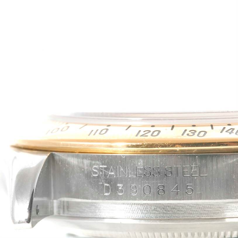 The image shows a close-up side view of the case and bezel of a Rolex Daytona 116523 Men's Steel and Gold (two tone) Black Dial 116523 Men's Steel and Gold (two tone) Black Dial watch, focusing on the serial number.