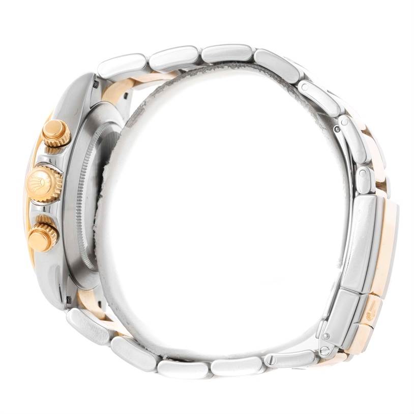 This is a side view of a Rolex Daytona 116523 Men's Steel and Gold (two tone) Black Dial 116523 Men's Steel and Gold (two tone) Black Dial watch showing the crown, pushers, and part of the bracelet.