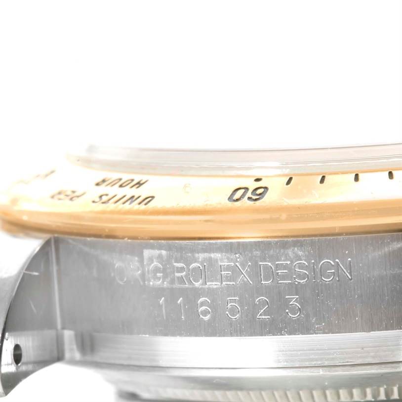 The image shows a close-up view of the side of a Rolex Daytona 116523 Men's White Dial 116523 Men's White Dial watch, highlighting the bezel and engraved model number.