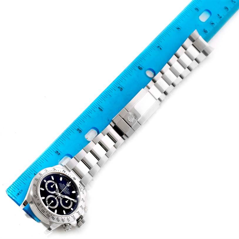 The image shows a top-view angle of a Rolex Daytona 116520 Men's Stainless Steel Black Dial 116520 Men's Stainless Steel Black Dial watch with a blue dial and metal bracelet measured by a blue ruler.