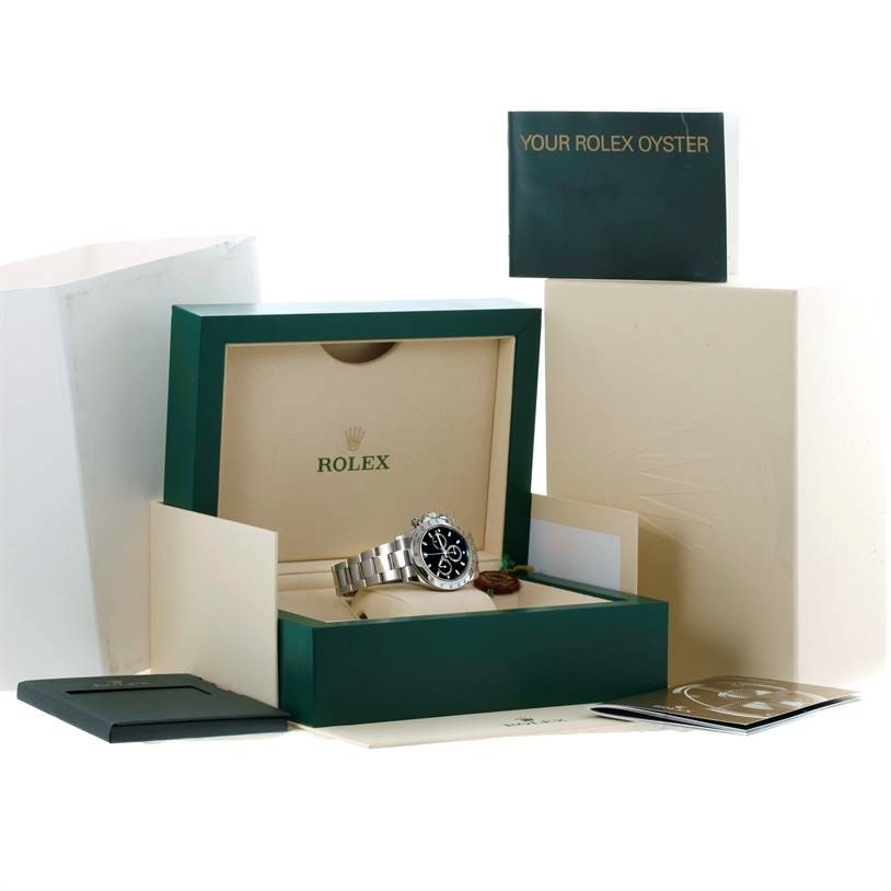 The image shows a Rolex Daytona 116520 Men's Stainless Steel Black Dial 116520 Men's Stainless Steel Black Dial watch in its open presentation box, surrounded by documentation and packaging.