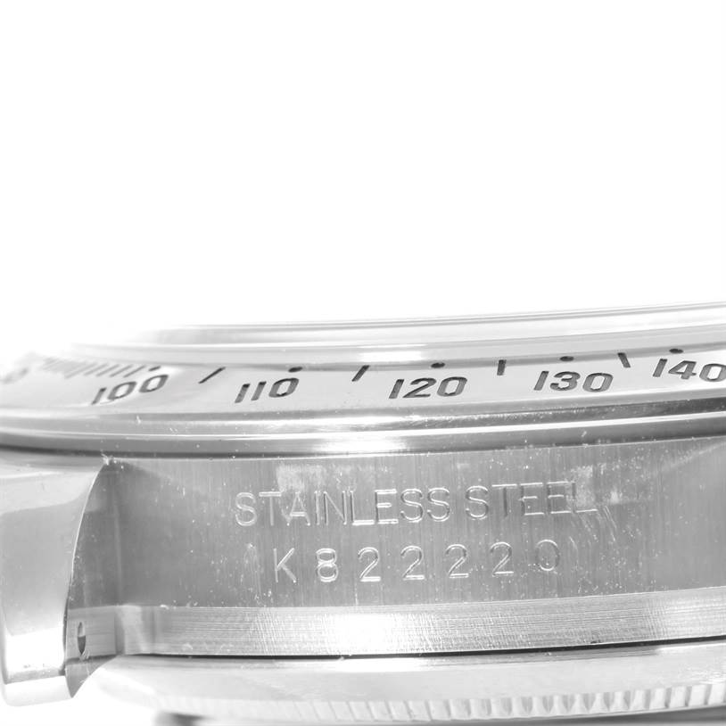 This image shows a close-up of the side of a Rolex Daytona 116520 Men's Stainless Steel Black Dial 116520 Men's Stainless Steel Black Dial watch, highlighting the serial number and part of the bezel with engraved markers.