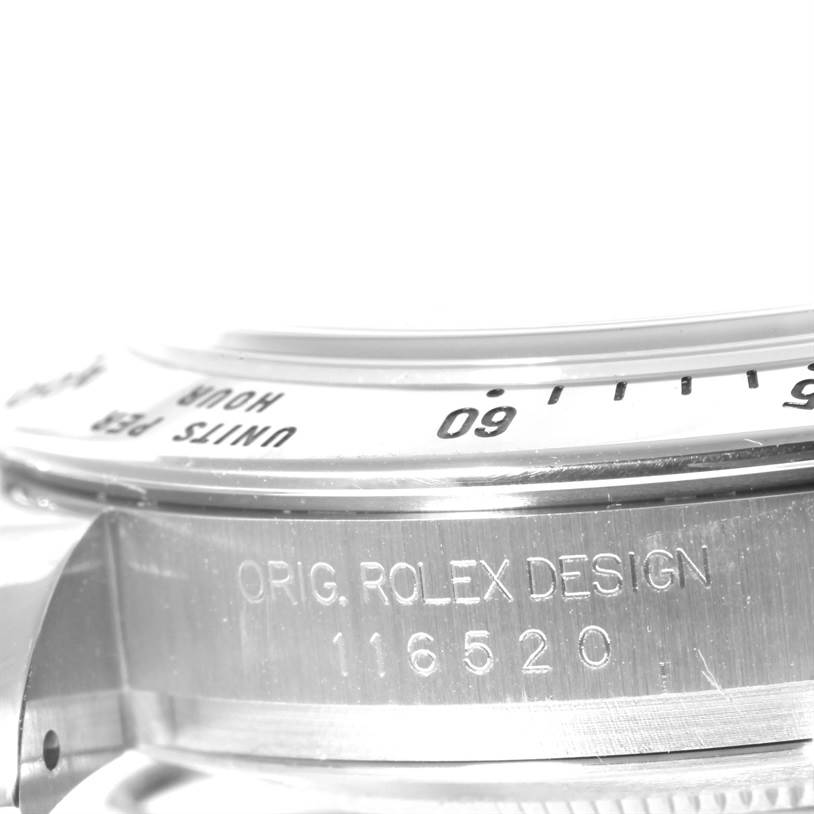The image shows a close-up of the side engraving and bezel of a Rolex Daytona 116520 Men's Stainless Steel Black Dial 116520 Men's Stainless Steel Black Dial watch.
