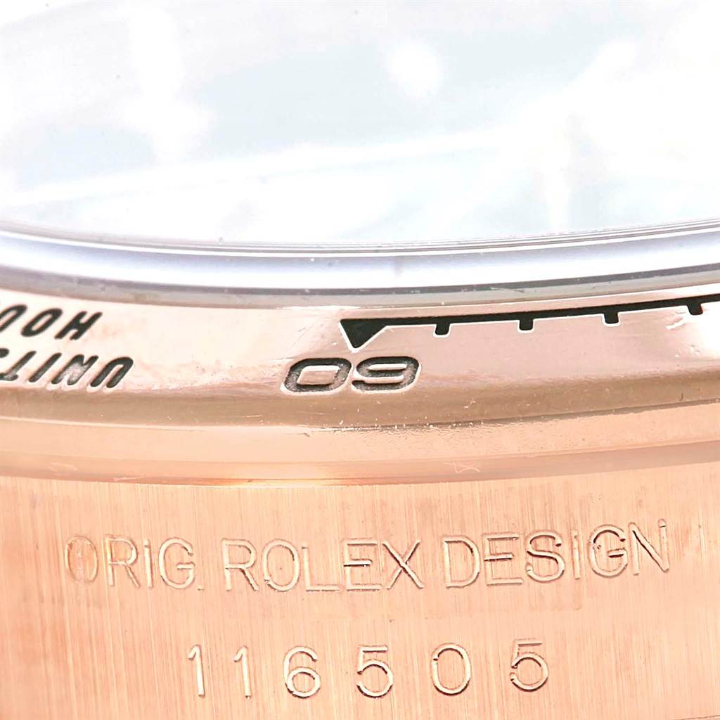 This close-up shows the bezel and part of the case back of a Rolex Daytona 116505 Men's Rose Gold Black Dial 116505 Men's Rose Gold Black Dial watch, model number 116505 with engravings.