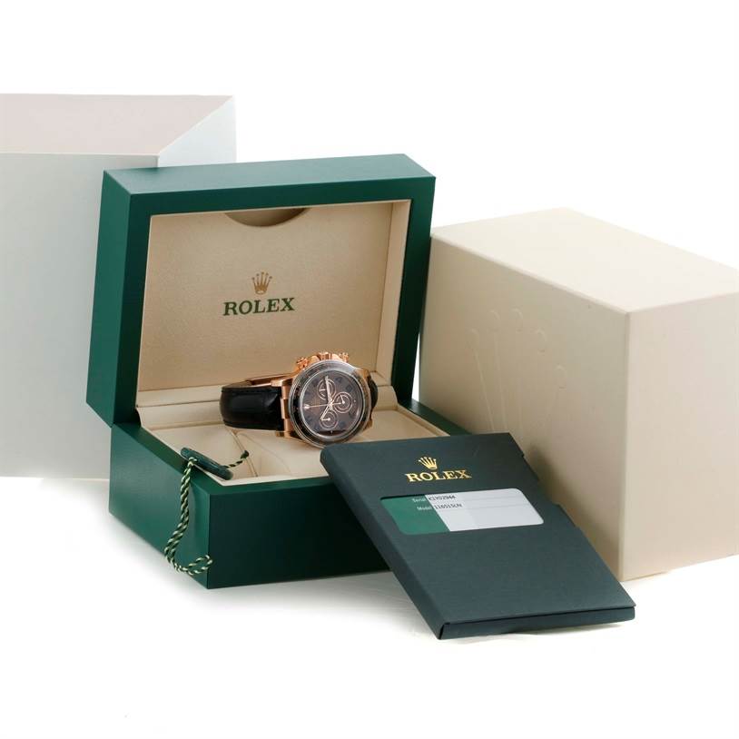 The Rolex Daytona 116515LN Men's Rose Gold Brown Dial 116515LN Men's Rose Gold Brown Dial watch is displayed in an open box at an angle, with related documents and packaging visible.